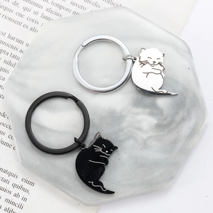 Cute black and silver cartoon cat couple keychains set on an octagon marble tray
