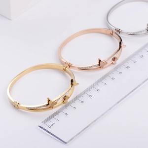 Trois bracelets papillon en or, rose et argent avec une règle pour mesurer la taille