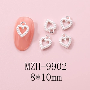 Detail of 8x10mm hollow heart nail charm with silver metal and white pearl inlay