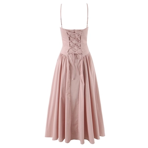 Détail de la robe rose à fines bretelles montrant le dos nu lacé et la taille plissée élégante
