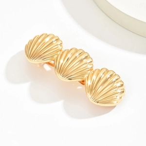 Detailed close-up of three connected golden shell hair clips with a polished metal finish