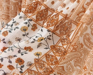 Detailed macro view of bohemian floral fabric texture with orange and brown patterns