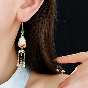 Detail of vintage Chinese style tassel earrings with golden lotus and enamel flower craft