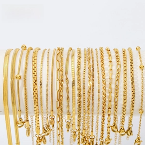 Close-up of assorted 18K gold plated stainless steel chain bracelets on a white stand