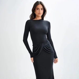 Détail d'une robe noire à manches longues avec taille froncée et coupe ajustée élégante