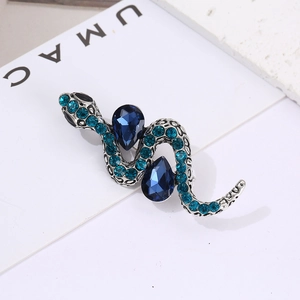 Detail of vintage silver snake brooch with deep blue pear-shaped stones and blue crystals
