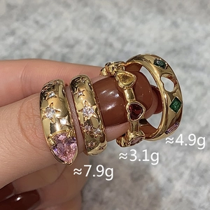 Detail view of gold-plated rings with colorful heart zircon and star carvings