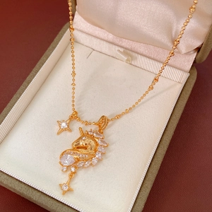 Macro shot of 18k gold plated unicorn necklace with sparkling zircon star accents