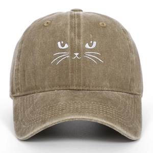 Detail of cute cat face embroidery on vintage washed cotton baseball cap in dark khaki