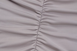 Macro shot of light purple elastic knitted fabric showing detailed stitching and texture