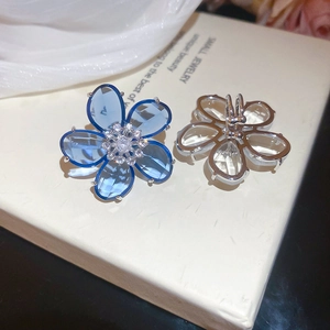Macro shot of blue zircon crystal flower earrings with detailed silver metal backing