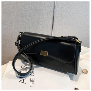 Detail einer minimalistischen schwarzen Ledertasche mit goldener Schnalle und Glanz-Finish