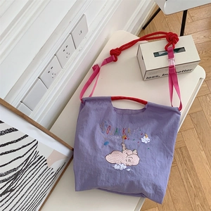 Detail of cute elephant embroidery and textured purple fabric on this tote bag