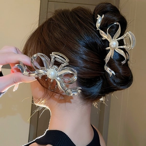 Détail de la pince à cheveux noeud argenté avec perle centrale sur le modèle