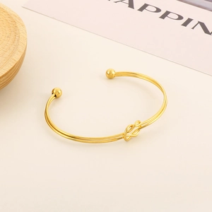 Bracelet jonc doré minimaliste avec nœud, design double ligne et embouts sphériques polis