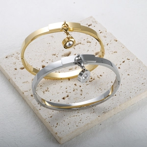 Detail of gold and silver Roman numeral bangles with sparkling zircon charms