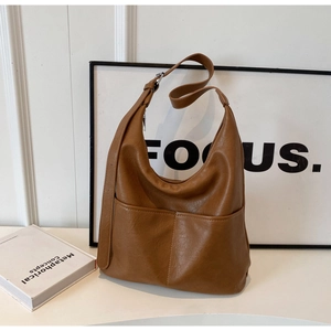 Close-up of vintage brown leather underarm bag with adjustable strap and front pocket detail