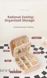 Detail view of pink jewelry travel case with mirror and partitioned storage layout