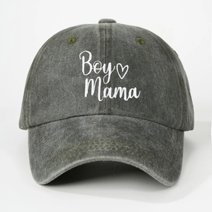 Close-up of white Boy Mama embroidery and green eyelets on dark grey washed cotton baseball cap