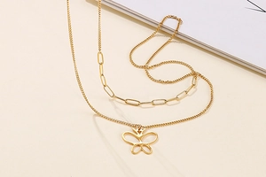 Detail of gold double-layered butterfly pendant necklace with paper clip chain texture