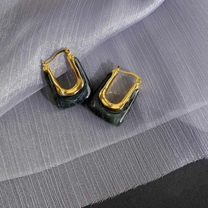 U-shaped 18K gold plated earrings with dark marble resin on grey mesh fabric