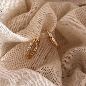 Macro shot of gold-plated hoop earrings featuring micro-pave white zircon stones