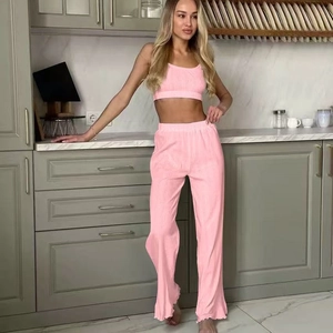 Pink two-piece loungewear set with camisole top and high-waisted ribbed knit trousers