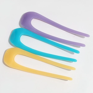 Three jelly-colored U-shaped acetate hair pins in purple, teal, and yellow hues