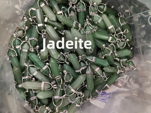 Macro view of bulk hexagonal aventurine jade crystal pendants with silver metal clasps