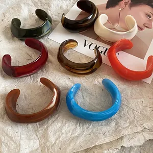 Stack of wide acrylic resin open bangles in marble and tortoiseshell patterns