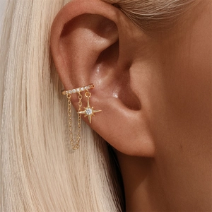 Close-up of gold S925 sterling silver ear cuff with starburst pendant on model