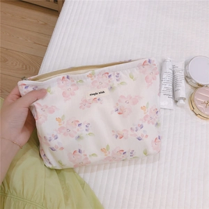 Close-up of floral canvas makeup bag with watercolor patterns and simple wish label