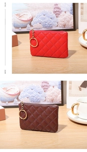 Detail of red and brown quilted PU leather coin purses with golden zippers on wooden desk