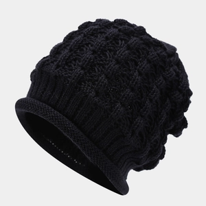 Close-up of thick black knit beanie showing the textured wave pattern and rolled edge