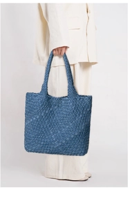 Detailed close-up of large blue woven denim tote bag showing intricate texture and capacity