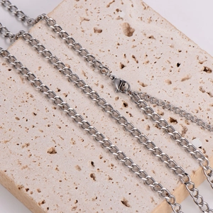 Sleek silver metal link chain necklace draped on a beige stone prop for a modern aesthetic