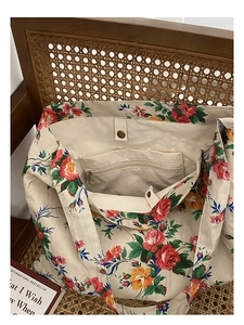 Detail of the interior zip pocket and magnetic closure on the floral canvas tote bag