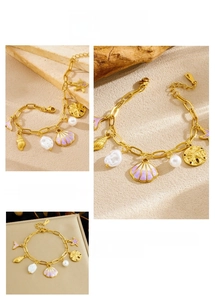 Close-up of gold ocean bracelet with enamel shells, pearls, and starfish charms