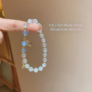 Star and moon charm beaded bracelet with white and blue cat eye stones for women