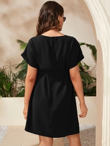 Detail of elegant black maternity dress showing back zipper and waist tie fastening