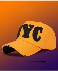 Detail of NYC patch embroidery on yellow cotton cap with vintage distressed brim effects
