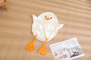 Flat lay of a white duck plush cushion skin on a light wood floor with a magazine