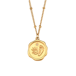 Collier doré avec pendentif à bord ondulé, empreintes de bébé et strass blanc