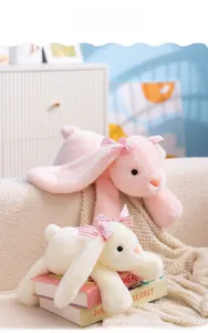 Détail de lapins en peluche doux rose et crème avec de jolis nœuds à carreaux