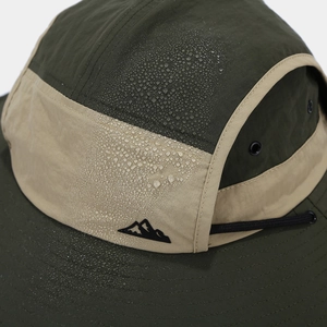 Macro detail of breathable outdoor sun hat fabric showing waterproof water droplets