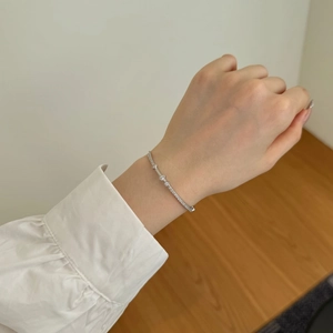 Close-up of S925 sterling silver Mobius bracelet with opal and zircon on a woman wrist