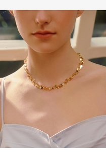 Close-up of gold heart sequin choker necklace showcasing layered metallic shine and texture