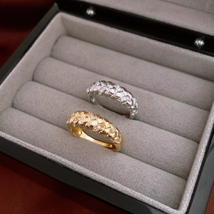 Macro shot of gold and silver twisted rope rings with zircons in a velvet jewelry box