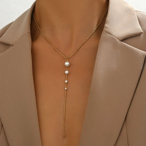 Golden fringe necklace with gradient pearls and snake chain on a blazer model