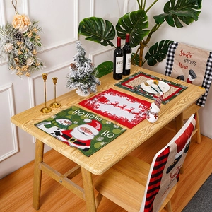 Detail of Christmas Santa placemats and chair covers on a wooden dining table